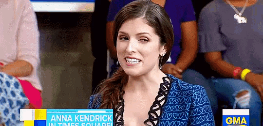 anna kendrick is sitting in front of a gma sign