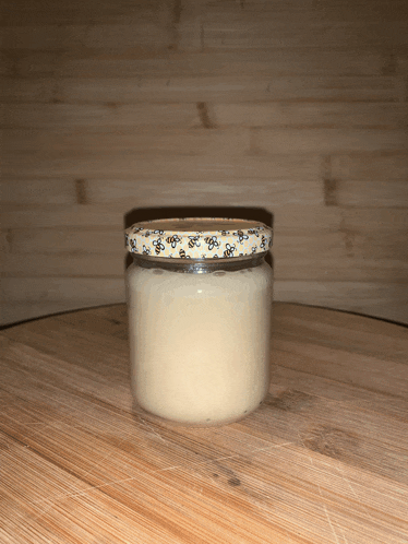 a jar with a bee design on the lid