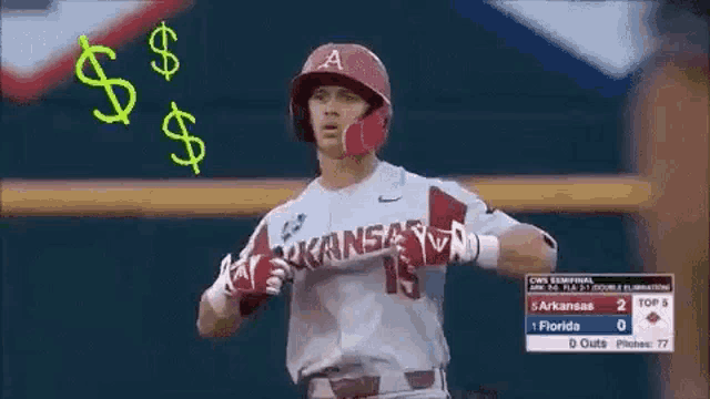 a baseball player wearing a helmet and gloves is running on a field with a dollar sign behind him .