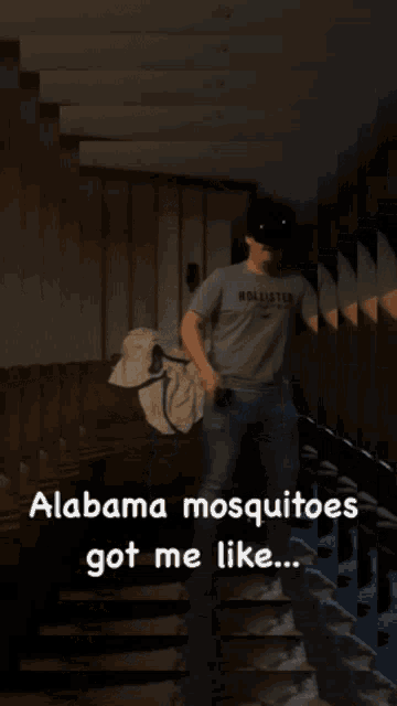 a man wearing a hollister shirt is standing in a dark room