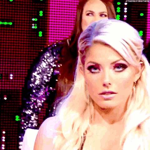 a close up of a blonde woman 's face with a pink background