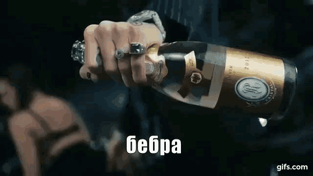 a person is holding a bottle of champagne with the word bebra written on the bottom