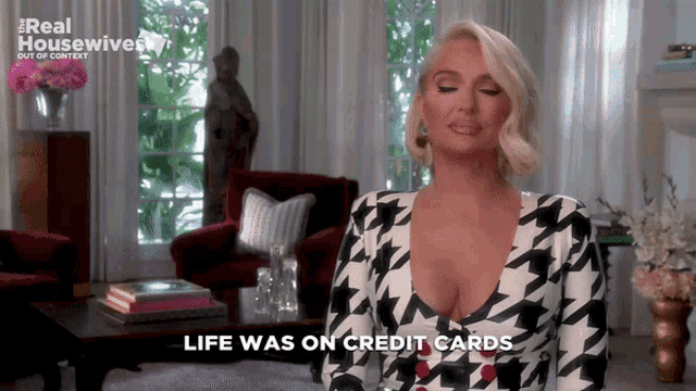 a woman in a black and white houndstooth dress says " life was on credit cards "