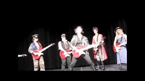 a group of people are playing guitars on stage