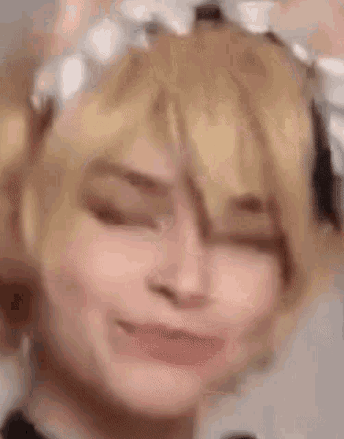 a close up of a person 's face with their eyes closed and a wig on .