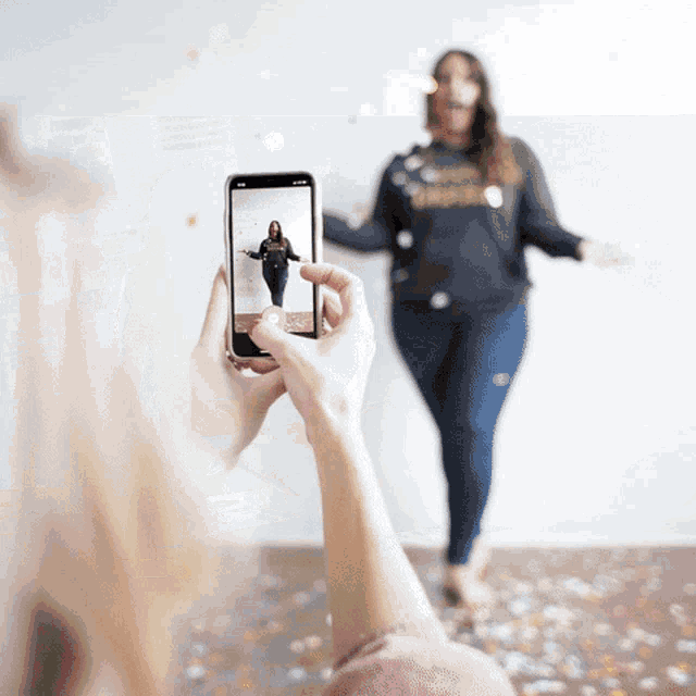 a woman taking a picture of another woman with a phone