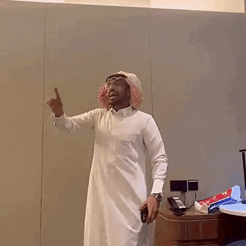 a man wearing a turban and a white shirt is dancing