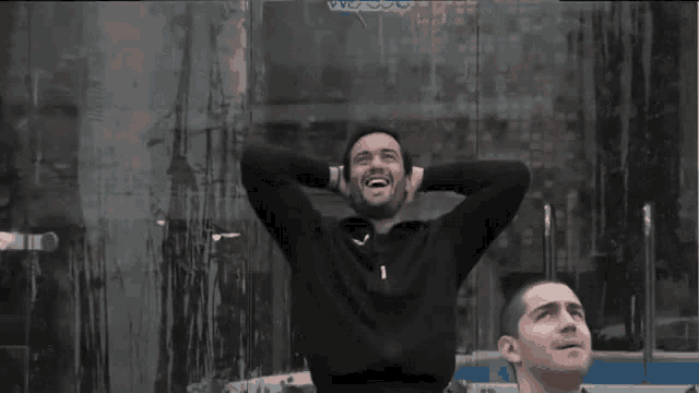 a man with his hands behind his head looks up at the sky