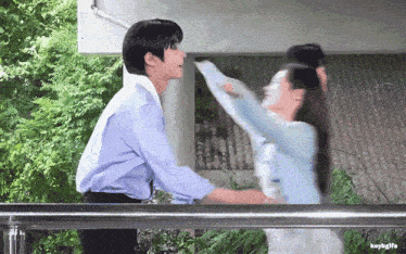 a man in a blue shirt is hugging a woman in a blue sweater