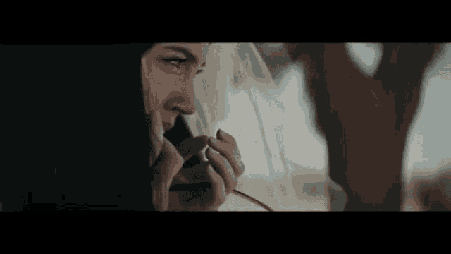 a woman in a veil is looking out of a window while talking on a cell phone .