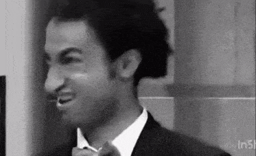 a black and white photo of a man in a suit and bow tie .
