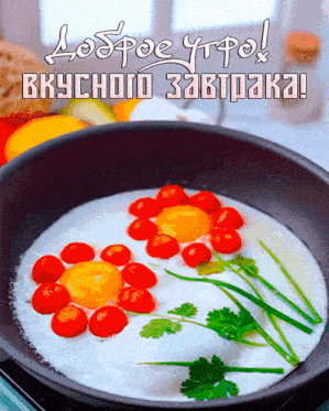 a frying pan filled with eggs and tomatoes with a greeting in another language