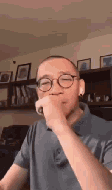 a man with glasses is singing into a microphone .