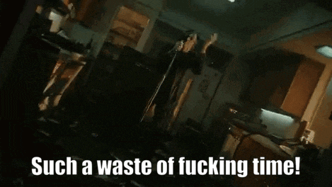 a man is standing in a kitchen with the words such a waste of fucking time
