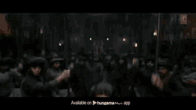 a man is standing in front of a crowd of people in a dark room .