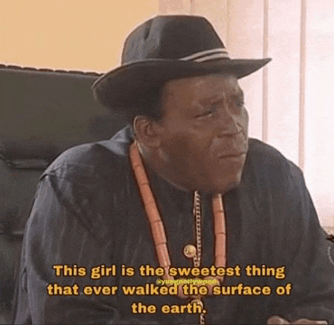 a man wearing a hat and beads is sitting in a chair with a quote .