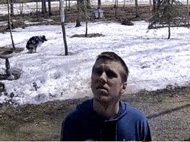 a man in a blue shirt stands in front of a snowy field .