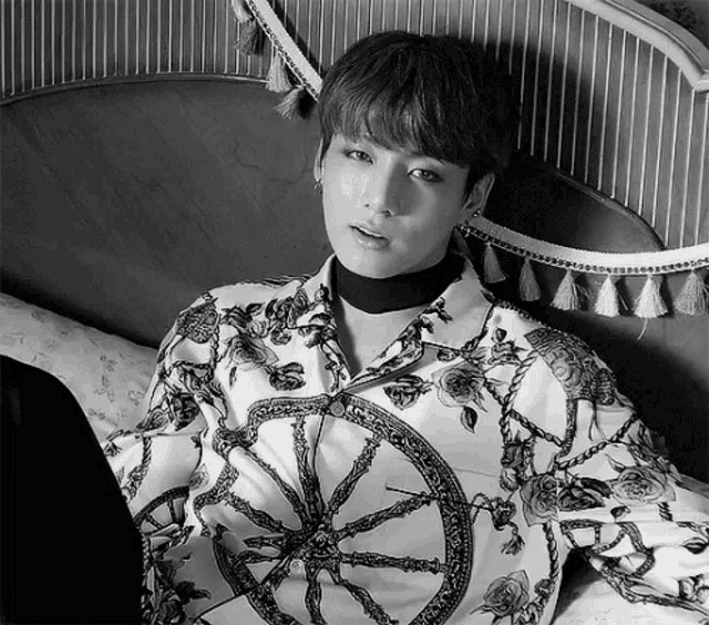 a black and white photo of a man wearing a shirt with a wheel on it