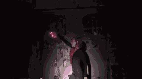 a woman with red hair stands in a dark room