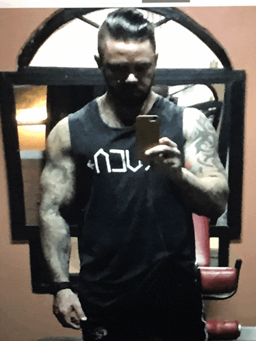 a man taking a selfie in front of a mirror with a shirt that says ncu