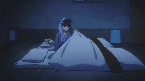 a person laying on a bed with a blanket on top of them