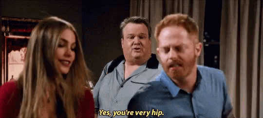 a man and a woman are standing next to each other and the man is saying `` yes , you 're very hip ''