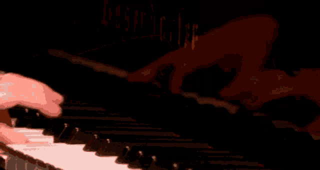 a close up of a person playing a piano with a blurred background of the word berger