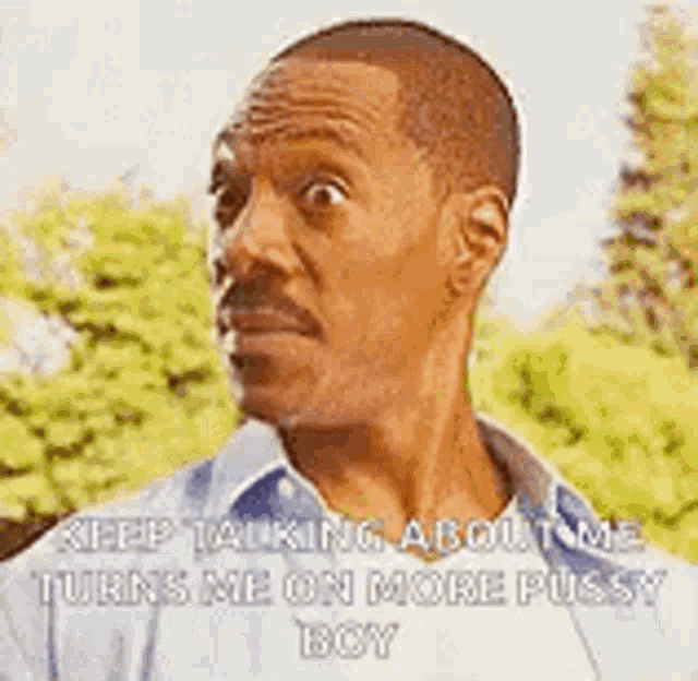 a man with a mustache is talking to another man while wearing a blue shirt .