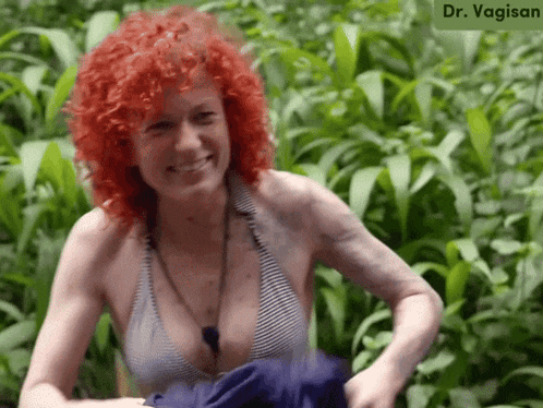 a woman with red hair is smiling in front of a sign that says dr. vaginan