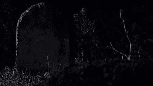 a person 's hand is sticking out of the ground in front of a grave .