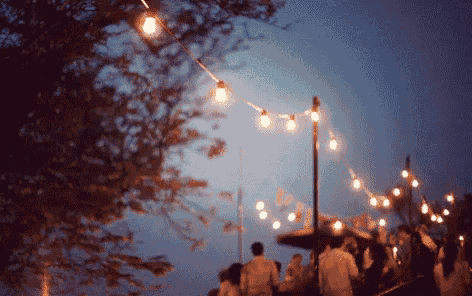 a string of lights hangs from a pole in the dark