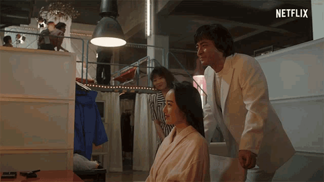 a man in a white suit is standing next to a woman in a robe in a room with a netflix logo