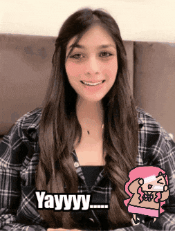 a woman in a plaid shirt is smiling and saying yayyy