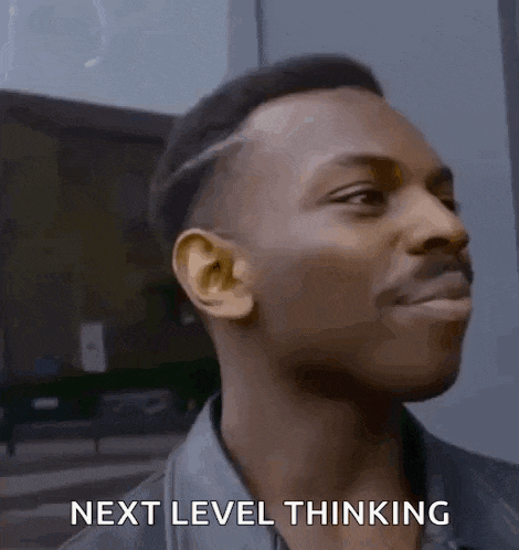 a man is smiling and saying `` next level thinking '' while standing in front of a building .