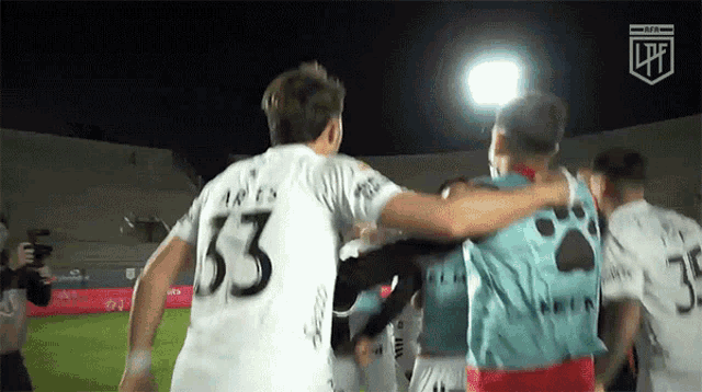 a soccer player with the number 53 on his jersey is hugging another player