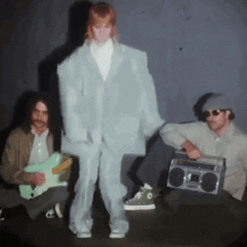 a man playing a guitar and a man holding a boom box