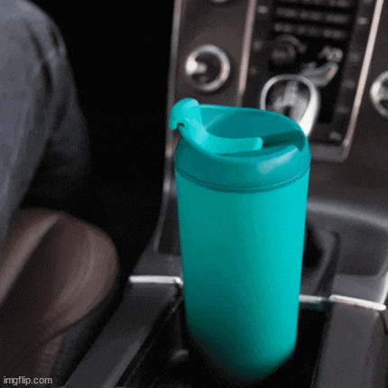 a blue coffee cup is sitting in a car cup holder ..