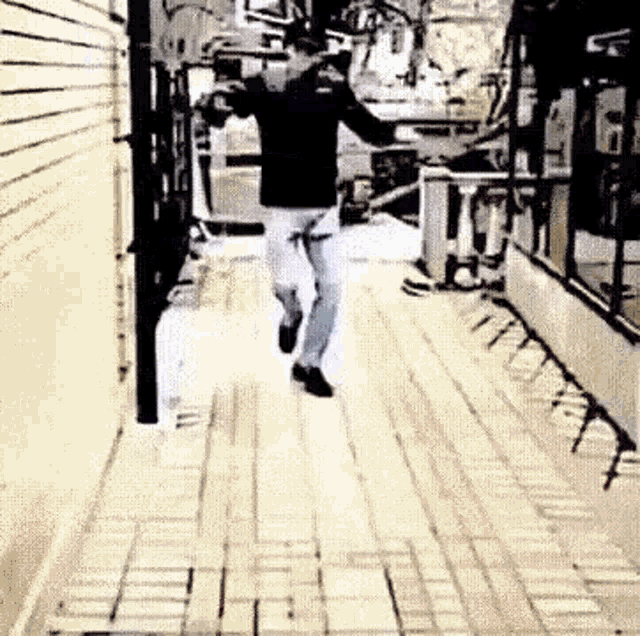 a man is running down a brick sidewalk in a black and white photo .