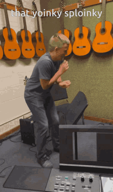 a man is dancing in front of a wall of guitars with the words that yoinky sploinky below him