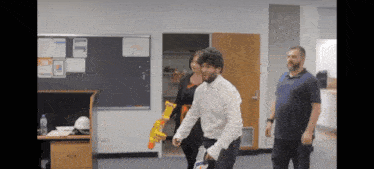 a man is holding a doritos gun while walking with two other people