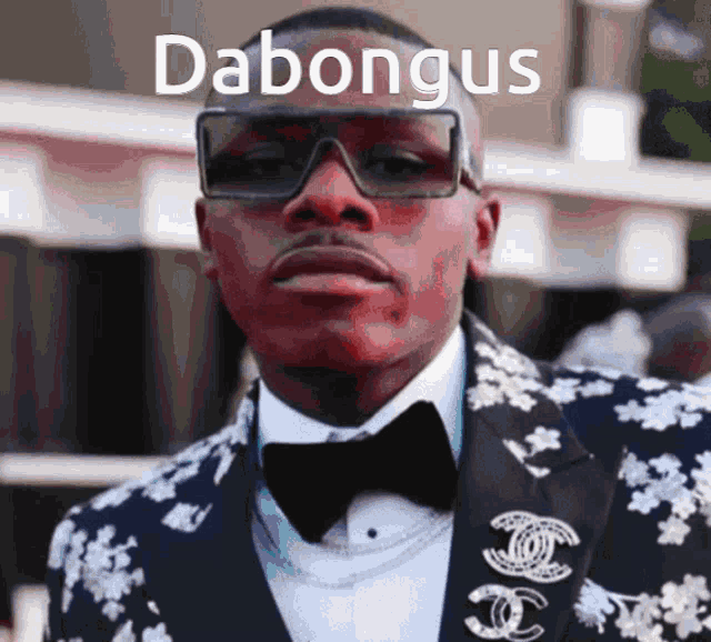 a man wearing sunglasses and a tuxedo has the name dabongus on the bottom