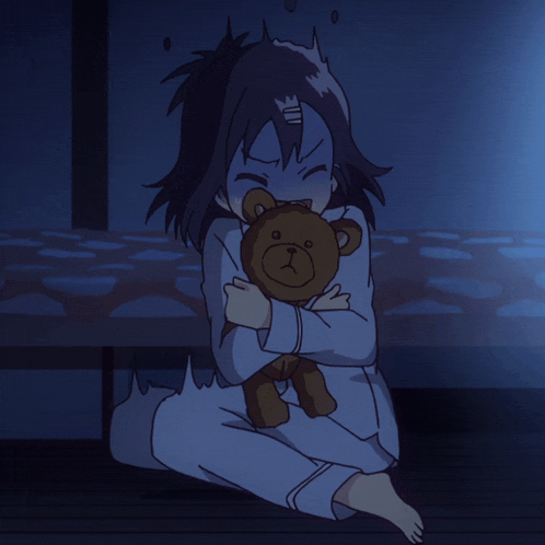 a little girl is holding a teddy bear in her lap