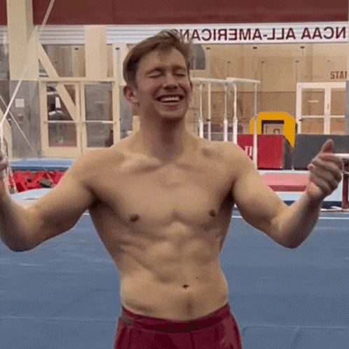 a shirtless man is smiling in front of a sign that says aao