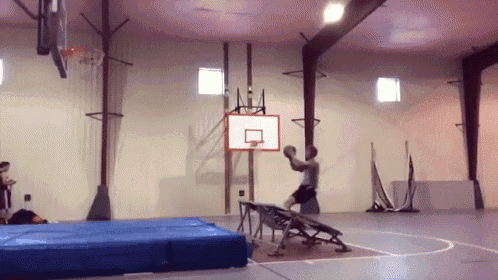 a man is playing basketball in a gym