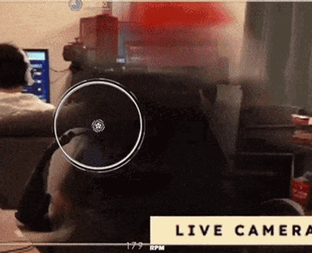 a blurred image of a person sitting in front of a computer with the words live camera in the corner