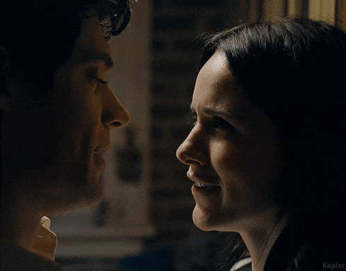 a man and a woman are looking at each other in a dark room with the word kepler in the corner