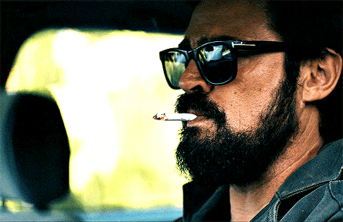a man with a beard is smoking a cigarette