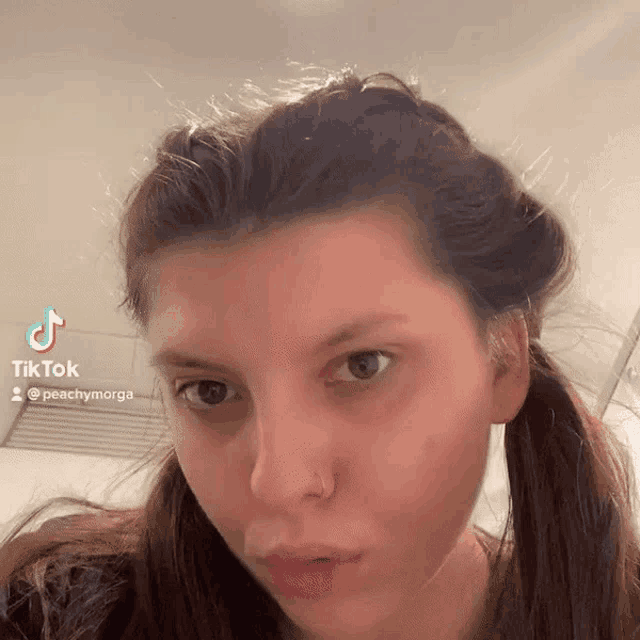 a close up of a woman 's face with a tiktok sticker on it