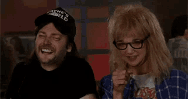 a man wearing a wayne 's world hat and a woman wearing glasses