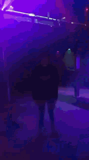 a blurry picture of a person in a dark room with a blue light behind them